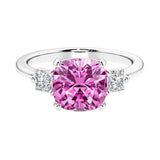 Cushion shaped engagement ring with brilliant diamonds and green gemstone.