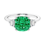 Cushion shaped engagement ring with brilliant diamonds and green gemstone.