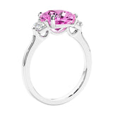 Cushion cut diamond ring as a unique engagement ring featuring three stone design with pink gemstone and diamonds.