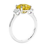 Cushion cut diamond ring as a unique engagement ring featuring three stone design with yellow gemstone and diamonds.