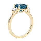 Three stone cushion diamond ring in yellow gold setting with alexandrite gemstone and diamonds.