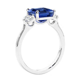 Asscher shaped ring in a timeless three stone ring set with diamond sides and blue sapphire center.