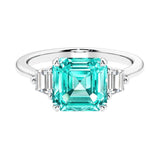 Asscher gemstone diamond ring with step-cut sparkle in a three stone setting featuring paraiba tourmaline center.