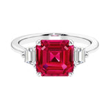 Asscher gemstone diamond ring with step-cut sparkle in a three stone setting featuring ruby center.