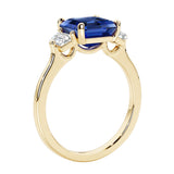 3 stone Asscher cut gemstone diamond ring in a classic Art Deco style featuring a blue sapphire center.