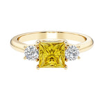Princess cut 3 stone engagement ring with side diamonds and yellow sapphire gemstone center.