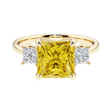 Princess cut 3 stone engagement ring with square side diamonds and yellow sapphire gemstone center.