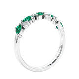Women’s anniversary ring with lab created green emerald and sparkling round diamonds in a vintage-inspired half eternity style.