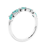 Women’s anniversary ring with lab created paraiba tourmaline and sparkling round diamonds in a vintage-inspired half eternity style.