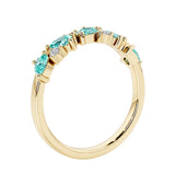 Unique 9 stone half eternity ring with pear shaped paraiba tourmaline and round diamond accents in yellow gold.