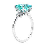 Women's unique ring with lab created paraiba tourmaline and sparkling round diamonds in a vintage-inspired cluster side stone style.