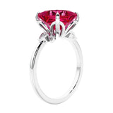 Women's unique ring with lab created ruby and sparkling round diamonds in a vintage-inspired cluster side stone style.