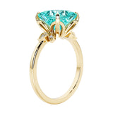 Unique nature inspired ring with princess cut paraiba tourmaline and round diamond accents in yellow gold.