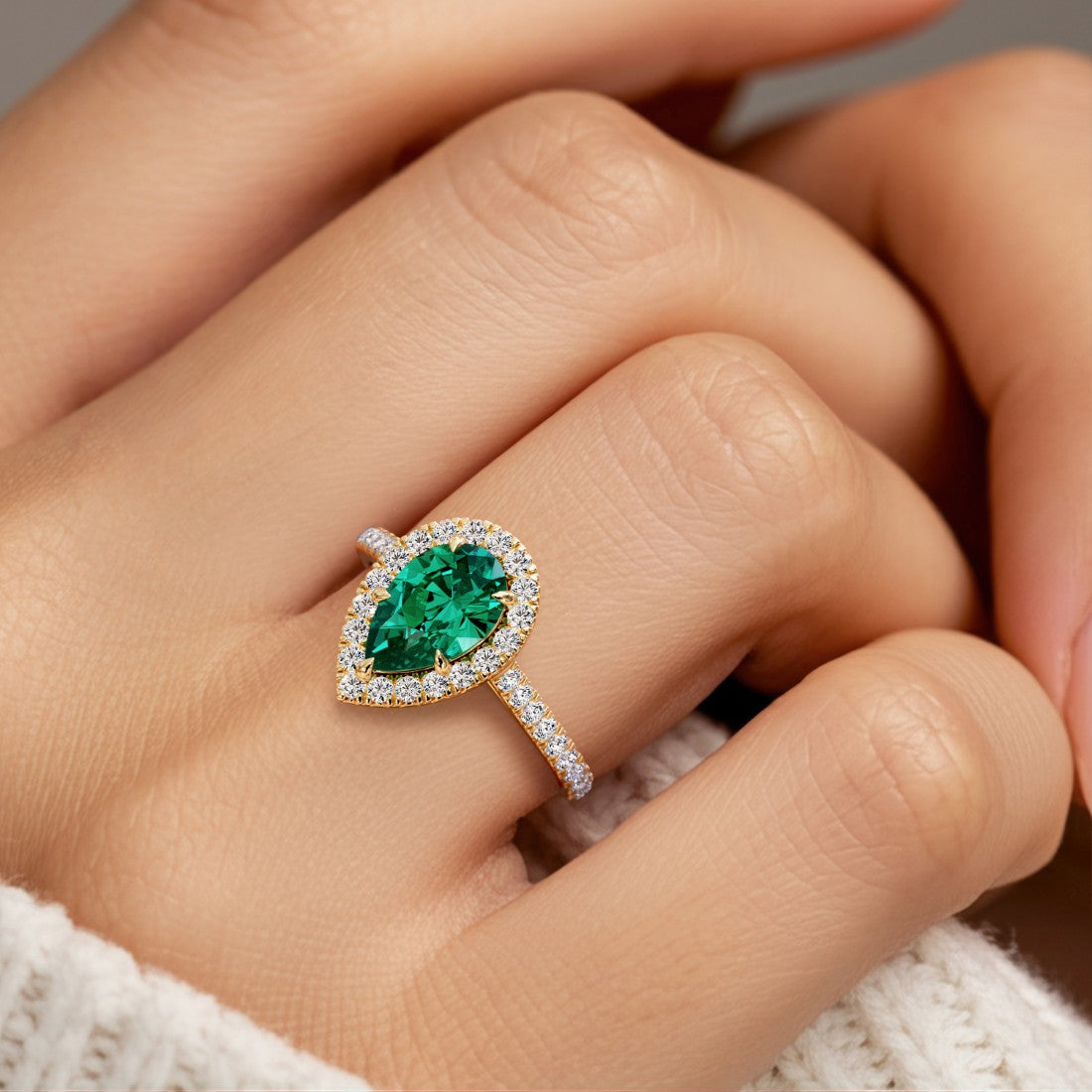 Woman wearing pear shaped alexadrite halo ring with diamonds.