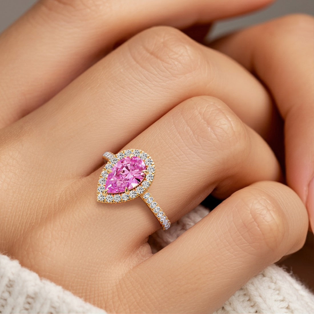 Woman wearing pear shaped alexadrite halo ring with diamonds.