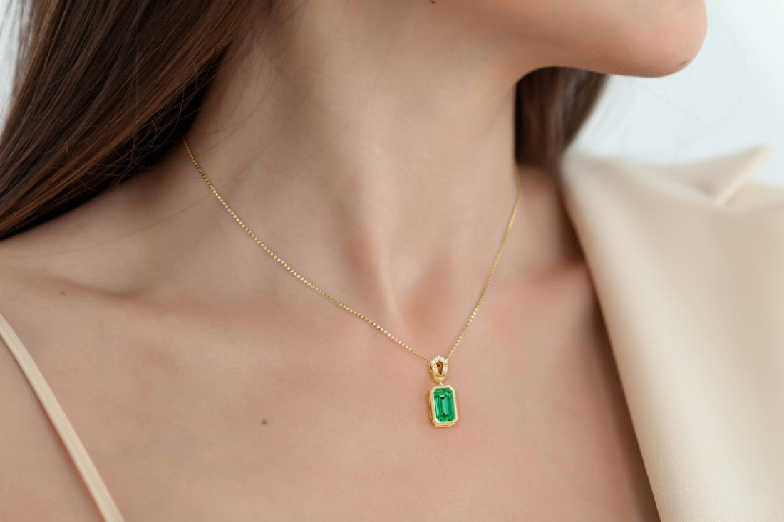 Gold necklace with a green gemstone pendant on a woman, custom necklace by Pel & Co