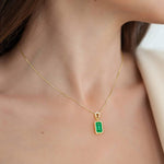 Gold necklace with a green gemstone pendant on a woman, custom necklace by Pel & Co