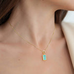 Woman wearing a green paraiba tourmaline necklace with bezel setting by Pel & Co.