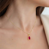 Gold necklace with a red ruby gemstone pendant for women.