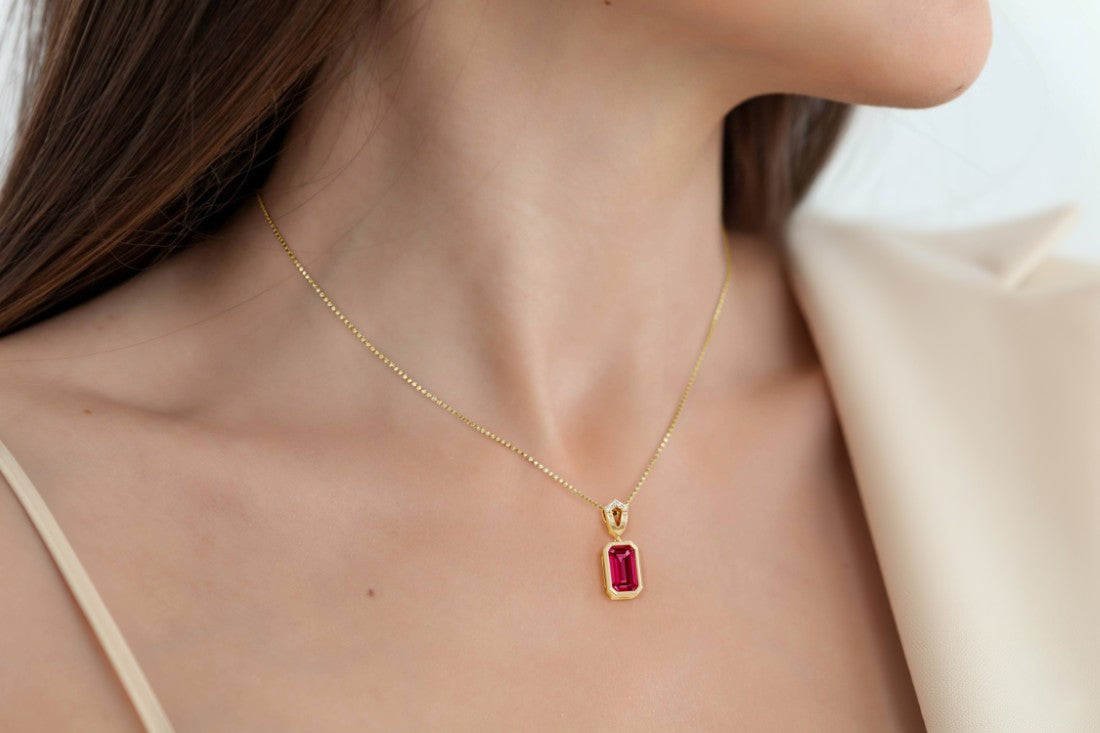 Gold necklace with a red ruby gemstone pendant for women.