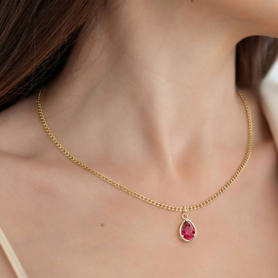 Woman wearing Pear Ruby Solitaire Pendant Necklace 14x10mm 8 Carat in 14K Gold with Cable Curb Chain
