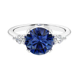 3 stone blue sapphire and diamond engagement ring with round center, symbolizing past, present, and future.
