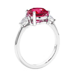 3 stone wedding ring featuring round red ruby center diamond and matching sides set in 14k white gold.
