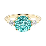 A 14k yellow gold three stone round engagement ring with a brilliant round paraiba green tourmaline center diamond and two round side stones.