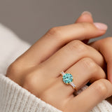 Woman wearing handcrafted round center gemstone engagement ring with sparkling diamond sides.