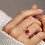 Woman wearing handcrafted round center gemstone engagement ring with sparkling diamond sides.