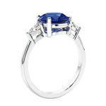 Round blue sapphire 3 stone engagement ring in white gold—a refined and popular choice among lab grown engagement rings.