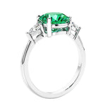 Round colombian emerald 3 stone engagement ring in white gold—a refined and popular choice among lab grown engagement rings.