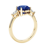 Lab diamond engagement ring with round blue sapphire center and two sparkling diamond side stones for timeless beauty.