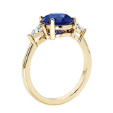 Lab diamond engagement ring with round blue sapphire center and two sparkling diamond side stones for timeless beauty.