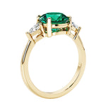 Lab diamond engagement ring with round emerald center and two sparkling diamond side stones for timeless beauty.