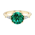 Handcrafted round center emerald engagement ring with sparkling diamond sides.