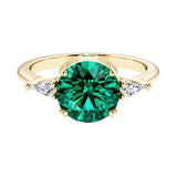 Handcrafted round center emerald engagement ring with sparkling diamond sides.