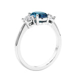 Oval cut three stone gemstone and diamond engagement ring with romantic charm.
