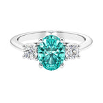 Three stone oval cut paraiba green tourmaline and diamond ring in classic design.