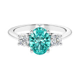 Three stone oval cut paraiba green tourmaline and diamond ring in classic design.