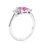 Oval cut three stone pink sapphire and diamond engagement ring with romantic charm.