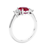 Oval cut three stone red ruby and diamond engagement ring with romantic charm.