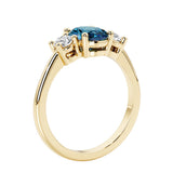 3 stone wedding ring with oval center gemstone and diamond side stones.