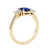3 stone wedding ring with oval center gemstone and diamond side stones.
