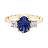 Oval 3 stone engagement ring with blue sapphire and brilliant diamond side stones.