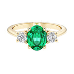 Oval 3 stone engagement ring with colombian emerald and brilliant diamond side stones.