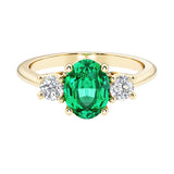 Oval 3 stone engagement ring with colombian emerald and brilliant diamond side stones.