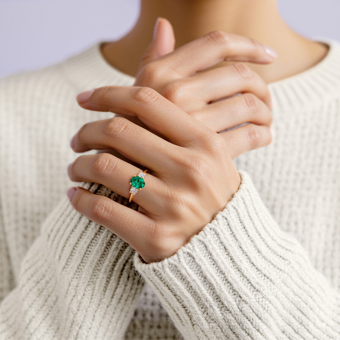Woman wearing oval shaped 3 stone engagement ring with soft sparkle.