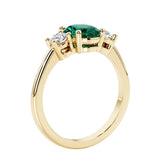3 stone wedding ring with oval center gemstone and diamond side stones.