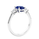 Oval cut three stone real blue sapphire and diamond engagement ring with romantic charm.